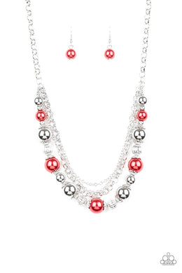 Layers of mismatched silver chains give way to a strand of ornate silver beads and oversized red pearls that cascade below the collar for a refined flair.