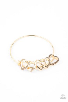 A glistening collection of airy gold heart charms that are stamped in the words, 