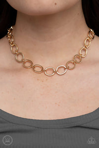 Imperfectly shaped gold circles link together around the neck for a gritty industrial statement.